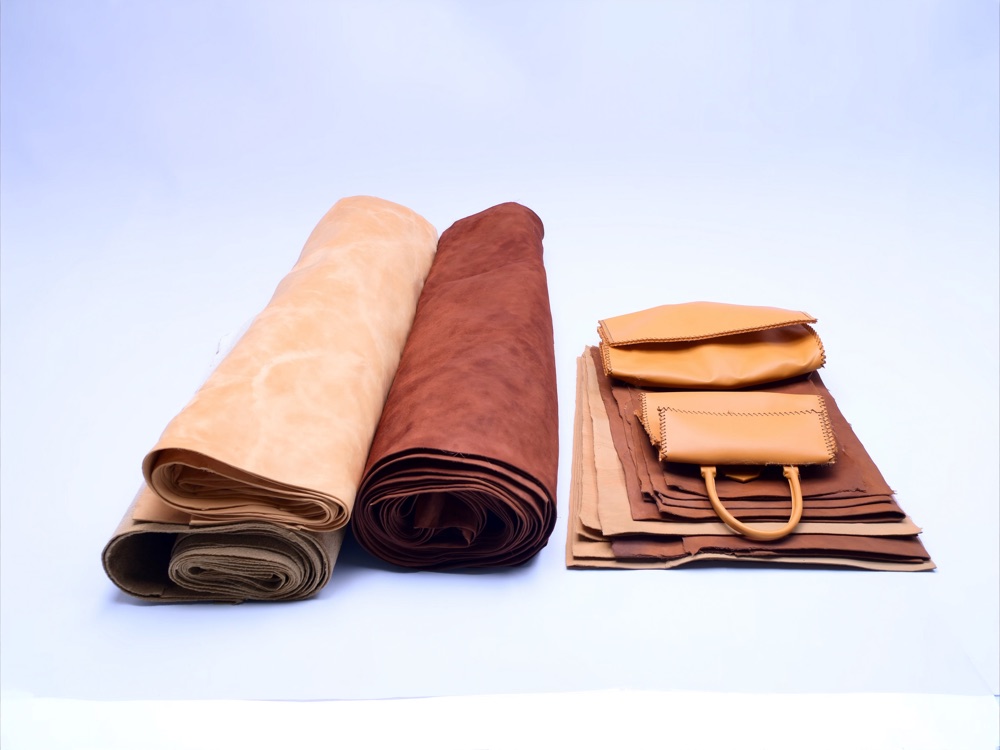 Rolls of tan and brown leather with finished leather goods